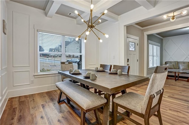 dining room with coffered ceiling, light hardwood / wood-style floors, crown molding, a notable chandelier, and beam ceiling