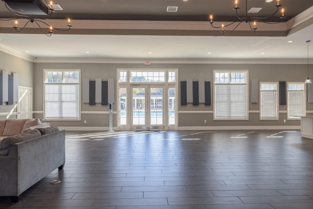 living room featuring ornamental molding, a chandelier, and french doors