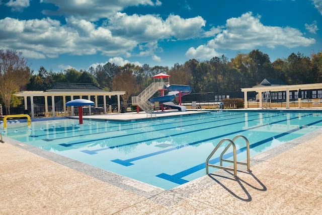 view of swimming pool featuring a water slide and a patio area