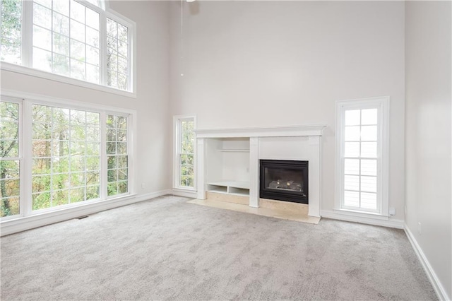 unfurnished living room featuring a high ceiling and a wealth of natural light