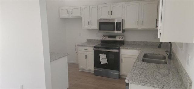 991 Park Creek Cir, Lawrenceville, GA 30044 - kitchen featuring appliances with stainless steel finishes, a sink, light wood finished floors, and white cabinets