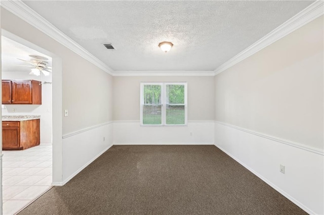 unfurnished room featuring ornamental molding, visible vents, a textured ceiling, and carpet flooring