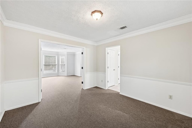 unfurnished room with crown molding, carpet flooring, a textured ceiling, and visible vents