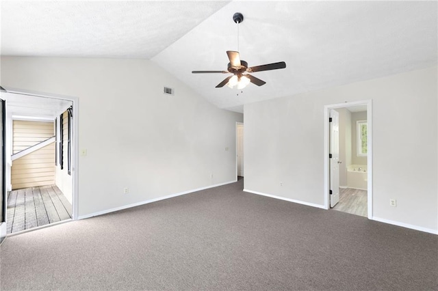 empty room featuring carpet, vaulted ceiling, visible vents, baseboards, and ceiling fan