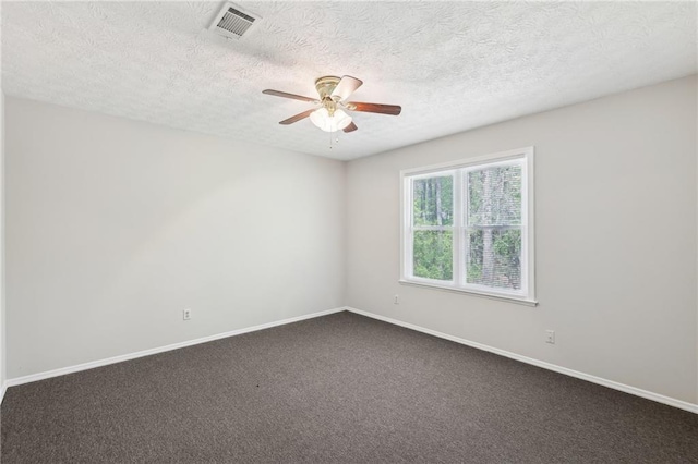 unfurnished room with a textured ceiling, visible vents, a ceiling fan, and baseboards