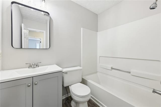 full bath with tub / shower combination, a textured ceiling, toilet, and vanity