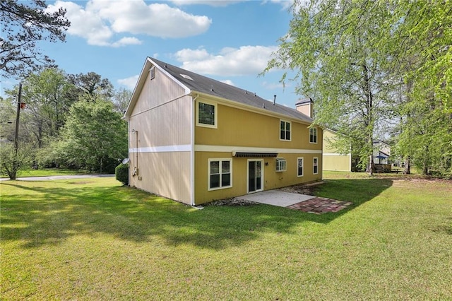 rear view of house featuring a patio area, a lawn, and a chimney