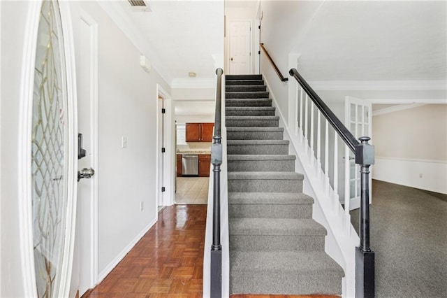 stairs featuring baseboards and ornamental molding