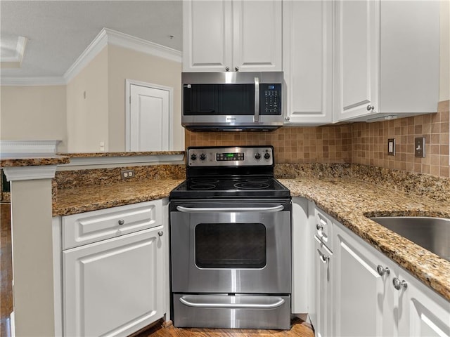 kitchen with white cabinetry, tasteful backsplash, appliances with stainless steel finishes, and ornamental molding