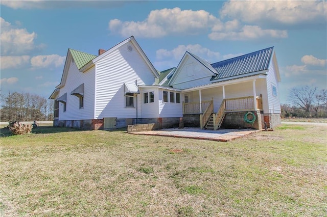 1782 Union Point Rd, Stephens, GA 30667 - rear view of property featuring a chimney, a lawn, metal roof, and covered porch