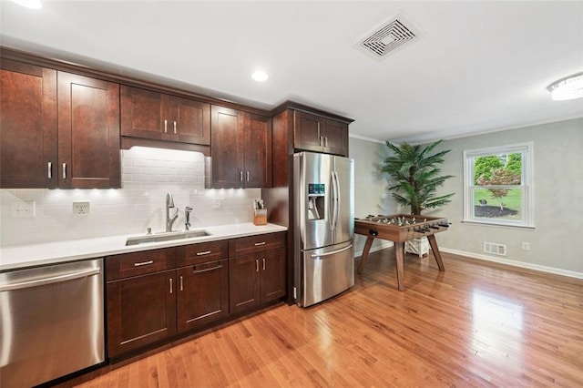 3415 Trickum Rd, Woodstock, GA 30188 - kitchen featuring stainless steel appliances, a sink, light wood finished floors, light countertops, and backsplash