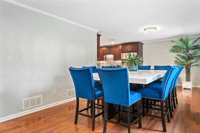 3415 Trickum Rd, Woodstock, GA 30188 - dining area with wood finished floors, baseboards, and crown molding