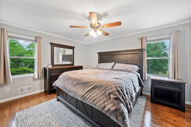 3415 Trickum Rd, Woodstock, GA 30188 - bedroom with multiple windows, wood finished floors, baseboards, and crown molding