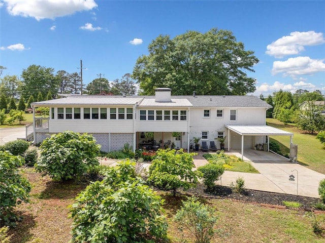 3415 Trickum Rd, Woodstock, GA 30188 - rear view of property featuring a carport, concrete driveway, and a chimney