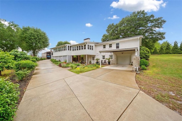 3415 Trickum Rd, Woodstock, GA 30188 - view of front of home with driveway, an attached garage, a front lawn, a chimney, and a sunroom