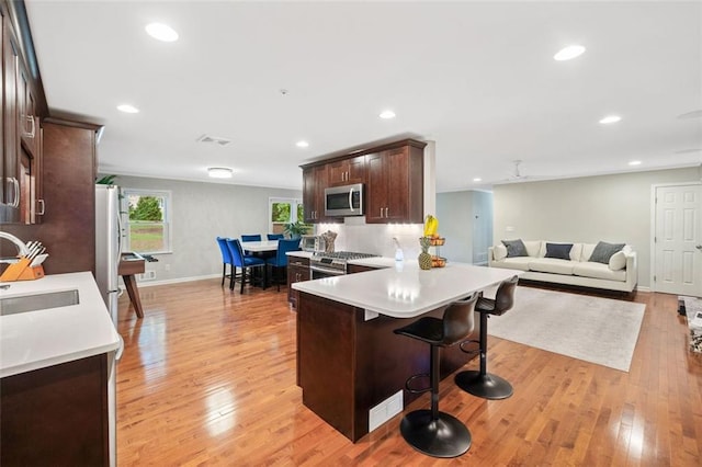 3415 Trickum Rd, Woodstock, GA 30188 - kitchen with stainless steel appliances, dark brown cabinets, a sink, light wood finished floors, and recessed lighting