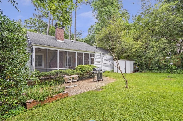 1908 E Roxboro Rd NE, Atlanta, GA 30324 - rear view of house featuring a sunroom, a patio, a storage unit, a lawn, and a chimney