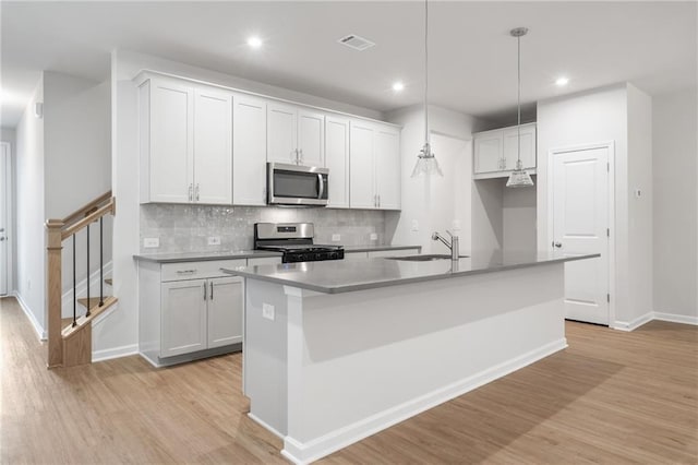 702 Smokey Quartz Way, Kennesaw, GA 30144 - kitchen featuring appliances with stainless steel finishes, light wood-style flooring, recessed lighting, a center island with sink, and backsplash