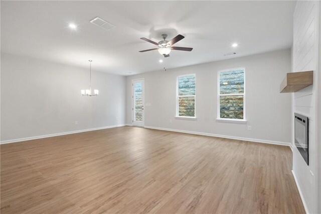 702 Smokey Quartz Way, Kennesaw, GA 30144 - unfurnished living room with a large fireplace, a chandelier, light wood-style floors, a ceiling fan, and recessed lighting
