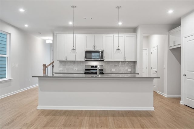 702 Smokey Quartz Way, Kennesaw, GA 30144 - kitchen with appliances with stainless steel finishes, tasteful backsplash, a sink, light wood-style flooring, and baseboards