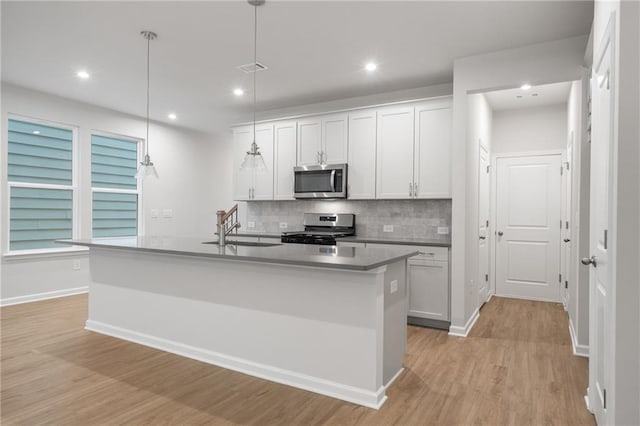 702 Smokey Quartz Way, Kennesaw, GA 30144 - kitchen featuring stainless steel appliances, a sink, tasteful backsplash, light wood-style floors, and white cabinets