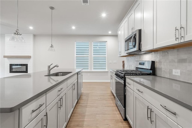 702 Smokey Quartz Way, Kennesaw, GA 30144 - kitchen with appliances with stainless steel finishes, a sink, light wood finished floors, backsplash, and recessed lighting