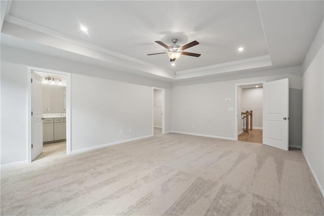 702 Smokey Quartz Way, Kennesaw, GA 30144 - unfurnished bedroom with crown molding, a tray ceiling, light carpet, connected bathroom, and baseboards
