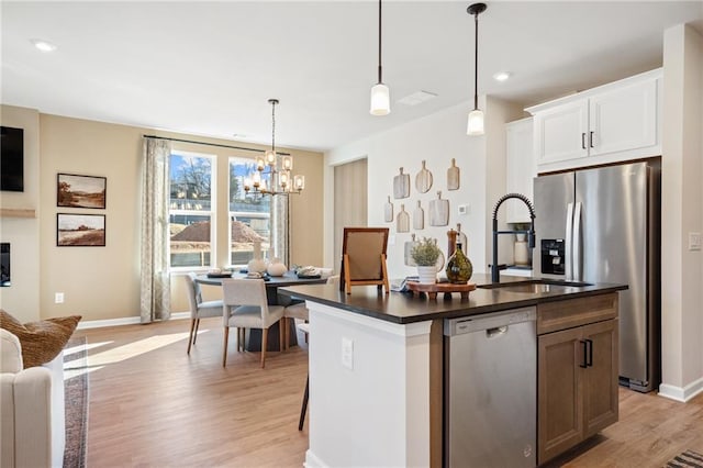 702 Smokey Quartz Way, Kennesaw, GA 30144 - kitchen featuring appliances with stainless steel finishes, dark countertops, light wood finished floors, a chandelier, and recessed lighting