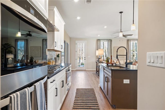 702 Smokey Quartz Way, Kennesaw, GA 30144 - kitchen featuring a ceiling fan, dark countertops, a sink, light wood finished floors, and stainless steel appliances
