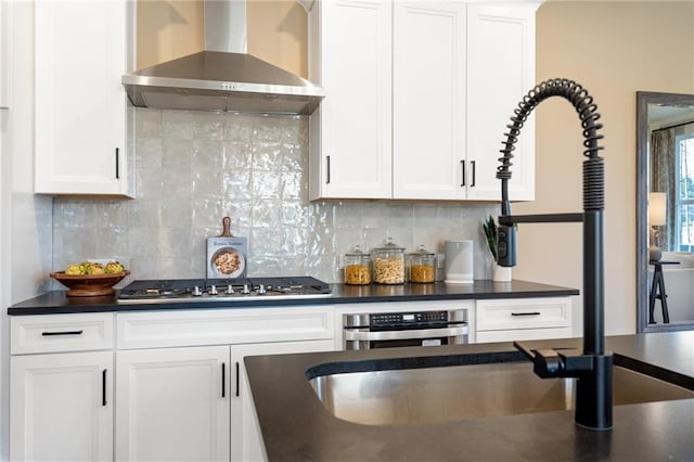 702 Smokey Quartz Way, Kennesaw, GA 30144 - kitchen featuring wall chimney range hood, dark countertops, white cabinets, and appliances with stainless steel finishes