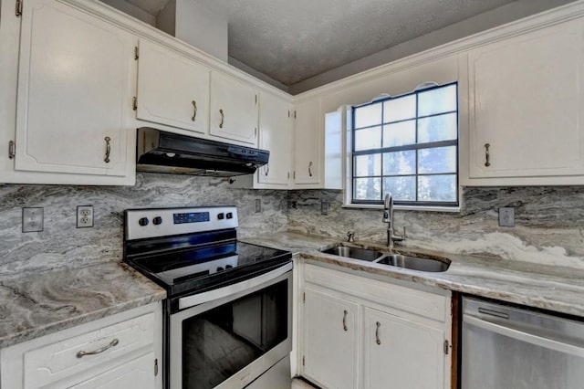 kitchen featuring appliances with stainless steel finishes, light countertops, under cabinet range hood, white cabinetry, and a sink