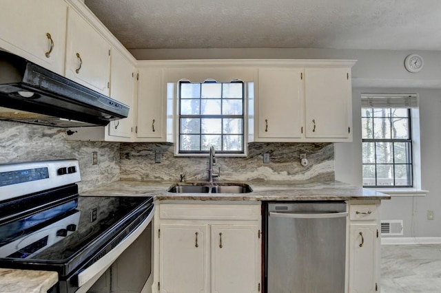 kitchen with under cabinet range hood, stainless steel appliances, a sink, visible vents, and white cabinets