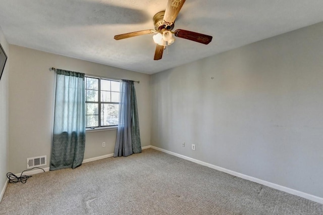 spare room featuring ceiling fan, carpet, visible vents, and baseboards