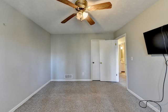unfurnished bedroom with a ceiling fan, baseboards, visible vents, and carpet flooring