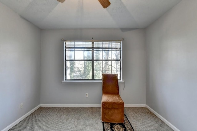 sitting room featuring a ceiling fan, carpet, and baseboards