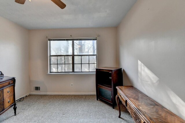 living area with baseboards, carpet, visible vents, and a ceiling fan