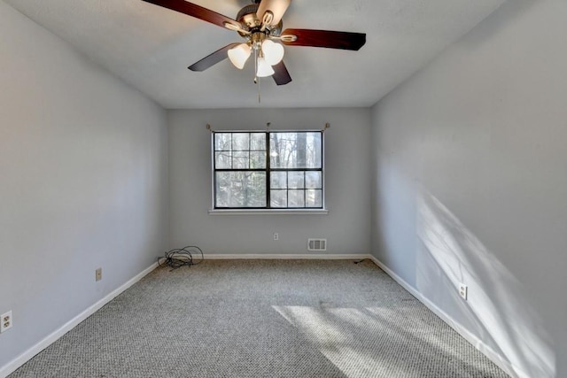 carpeted empty room featuring a ceiling fan, visible vents, and baseboards