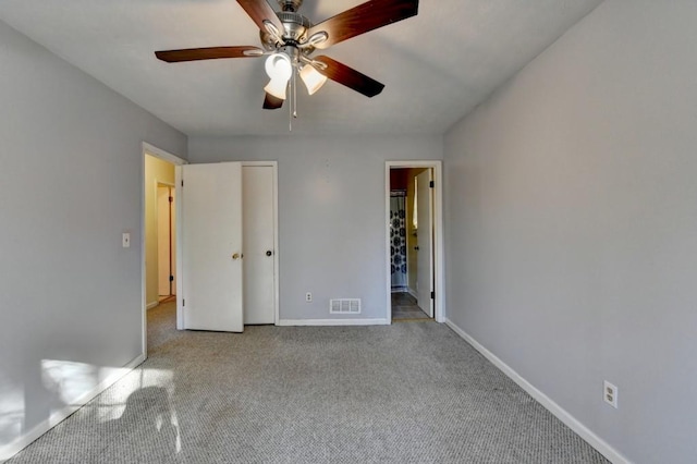 unfurnished bedroom featuring carpet floors, visible vents, ceiling fan, and baseboards