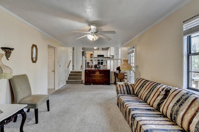 living room featuring light carpet, ceiling fan, stairs, and ornamental molding