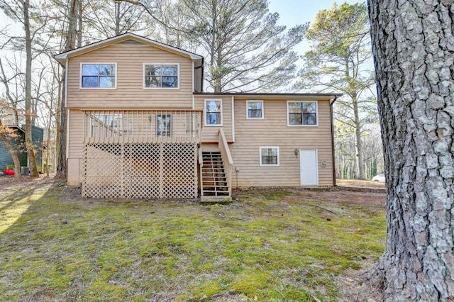 back of house featuring stairs, a lawn, and a wooden deck