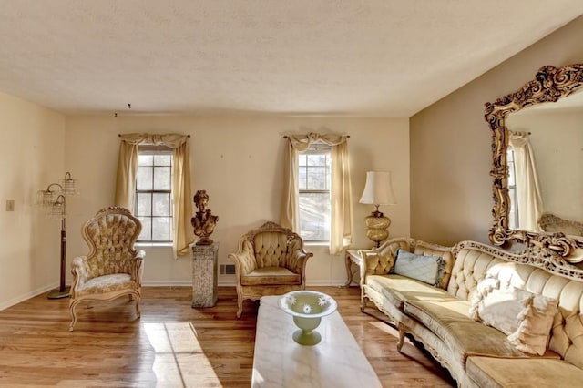 sitting room featuring a wealth of natural light, light wood-style flooring, and baseboards