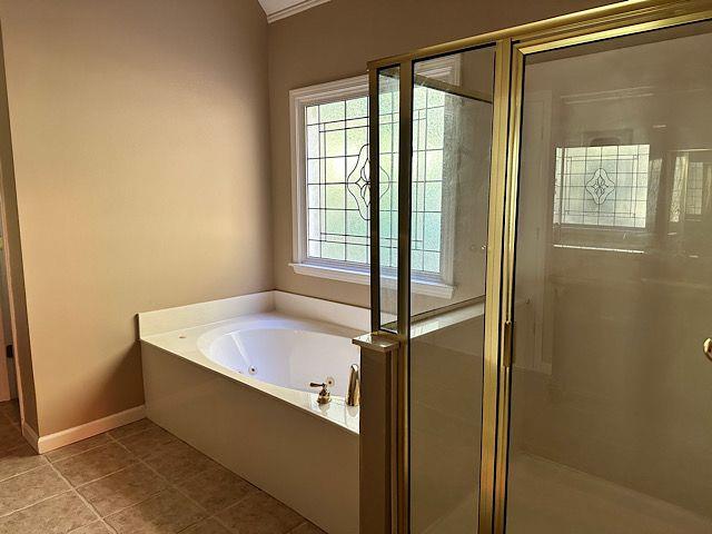 bathroom with tile patterned floors and independent shower and bath