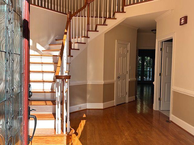 stairway with hardwood / wood-style floors and ornamental molding