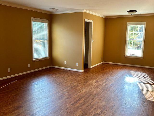 empty room with dark hardwood / wood-style floors and ornamental molding