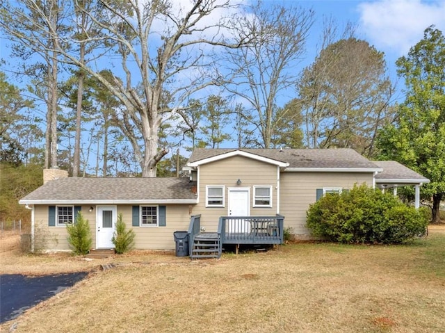 view of front facade with a wooden deck and a front yard