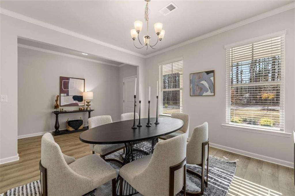 4517 Ajo Walk, Atlanta, GA 30331 - dining area featuring visible vents, baseboards, an inviting chandelier, ornamental molding, and light wood-style flooring