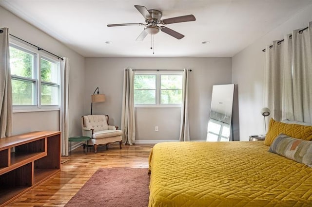 bedroom featuring multiple windows, ceiling fan, and light hardwood / wood-style flooring