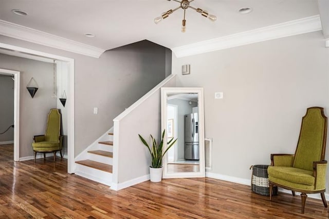 sitting room with hardwood / wood-style flooring and crown molding