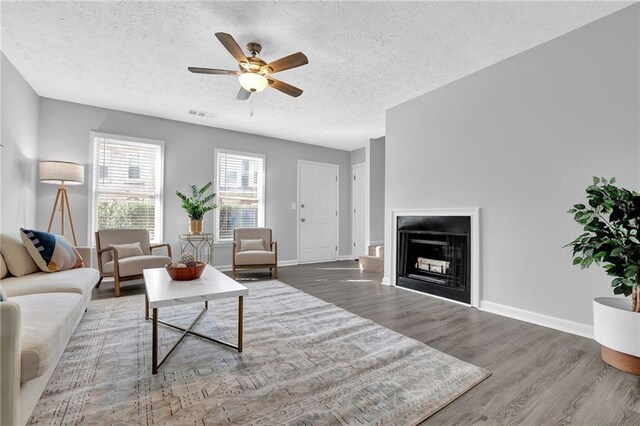 living room with dark hardwood / wood-style floors and ceiling fan with notable chandelier