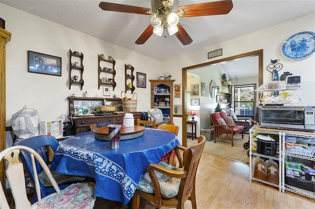 dining room with a toaster, visible vents, wood finished floors, and a ceiling fan